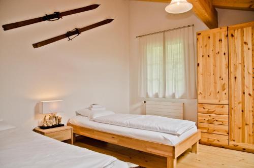 1 Schlafzimmer mit 2 Betten und einem Fenster in der Unterkunft Apartment Kiwi links - GRIWA RENT AG in Grindelwald