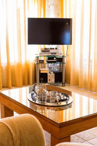 a glass table with a television on top of it at Amazing Sea View Villa in Parikia