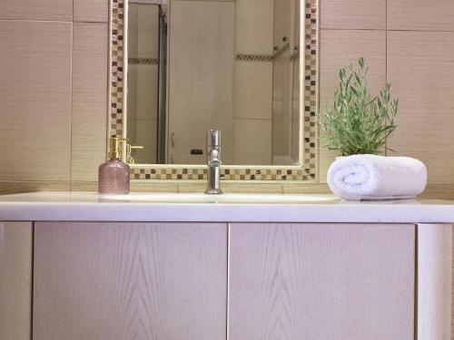 a bathroom counter with a sink and a mirror at Giovanna's Lux Apartment in Zakynthos