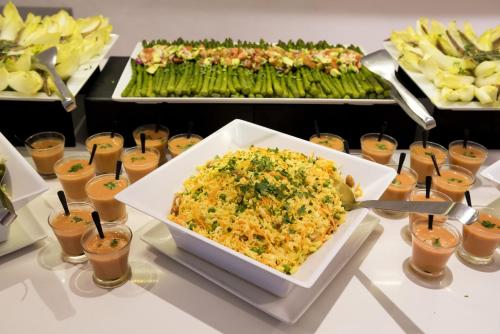 a buffet with a bowl of food on a table at Hotel Apartamentos Cala Santanyi in Cala Santanyi