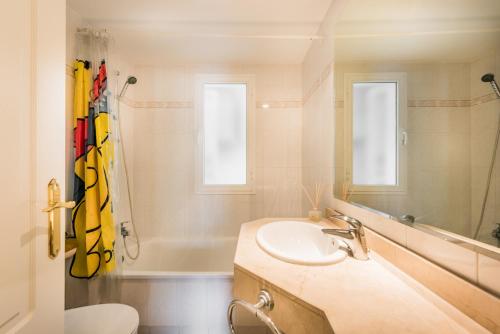a bathroom with a sink and a mirror and a tub at Puerto Bañus - Casa Pietro in Marbella