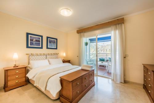 a bedroom with a large bed and a balcony at Puerto Bañus - Casa Pietro in Marbella