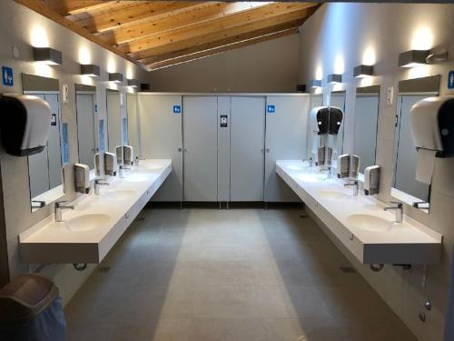 a bathroom with a row of sinks and stalls at Camping Vransko jezero - Crkvine in Pakoštane