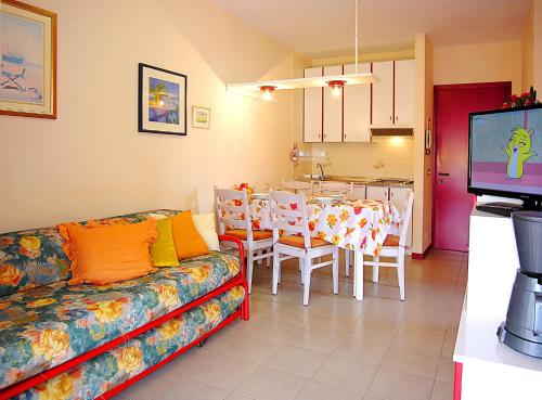 a living room with a couch and a table with chairs at Gabbiano Atlante in Bibione