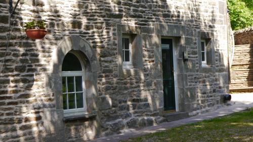 an old stone building with a potted plant on it at Elysian Fields @ Ing Hill Lodge in Outhgill