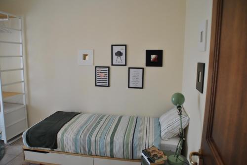 a bedroom with a bed with pictures on the wall at Casa Sa serra in Lotzorai