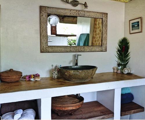 un baño con lavabo y espejo en Island Home, en Uturoa