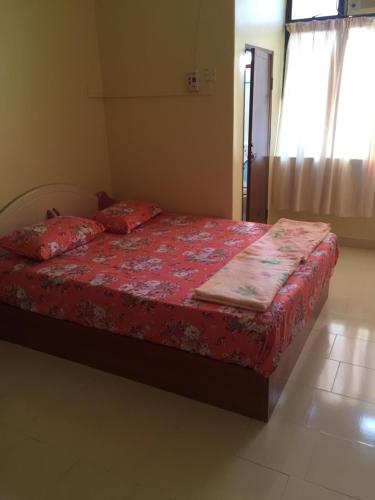Pangkor 16 Homestay في بانكور: غرفة نوم مع سرير مع لحاف احمر