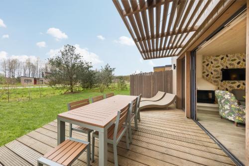 una terraza de madera con mesa y sillas. en Center Parcs Villages Nature Paris, en Bailly-Romainvilliers