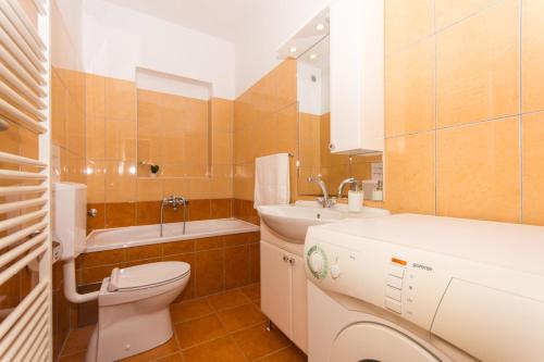 a bathroom with a toilet and a sink and a tub at Apartman Domić in Slatine