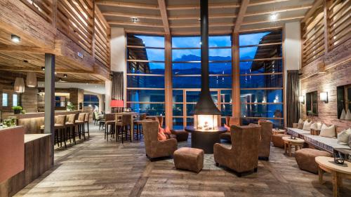 a lobby of a hotel with a fireplace and chairs at Miraval NaturHotel in Badia