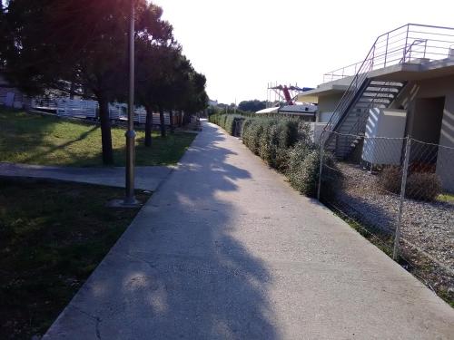 a sidewalk with a parking meter next to a fence at Apartmani Vesna Supetar in Supetar