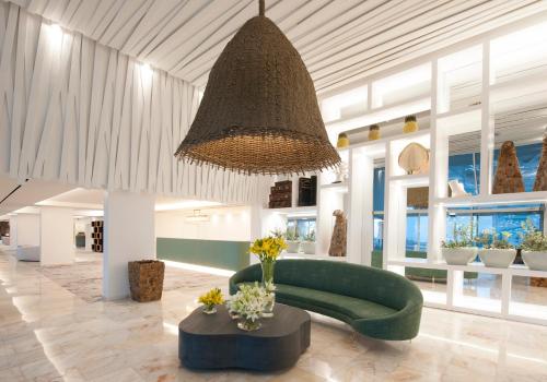 a living room with a green couch and a chandelier at Hotel Alto Lido in Funchal