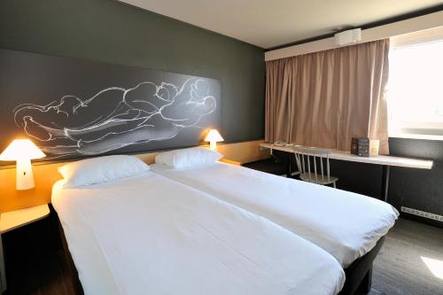 A bed or beds in a room at Ibis Lyon Villefranche Sur Saone