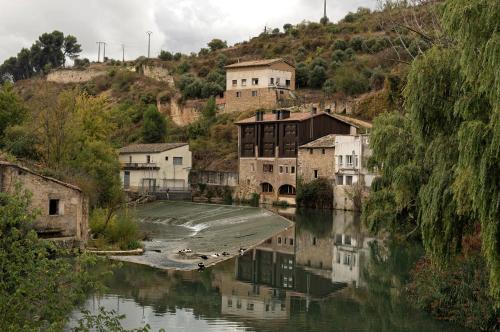 a group of houses on a hill next to a river at Hostería de Curtidores in Estella