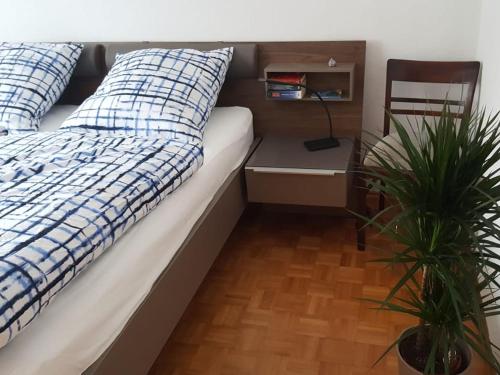 uma cama com almofadas azuis e brancas e uma cadeira em Apartment Nelli em Albstadt