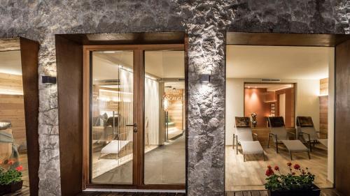 a hallway with glass doors leading to a dining room at Miraval NaturHotel in Badia