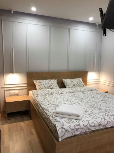 Schlafzimmer mit einem großen Bett mit einem Kopfteil aus Holz in der Unterkunft LUX Apartment Ruska in Lwiw