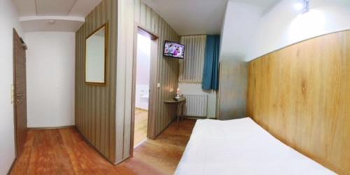 ein Schlafzimmer mit einem Bett und einem TV in der Unterkunft Hotel Am Markt in Oebisfelde