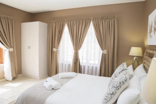 a bedroom with a white bed with towels on it at Augrabies Falls Lodge & Camp in Augrabies