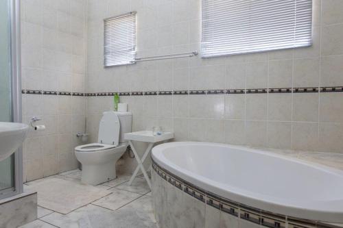 a bathroom with a tub and a toilet and a sink at Augrabies Falls Lodge & Camp in Augrabies