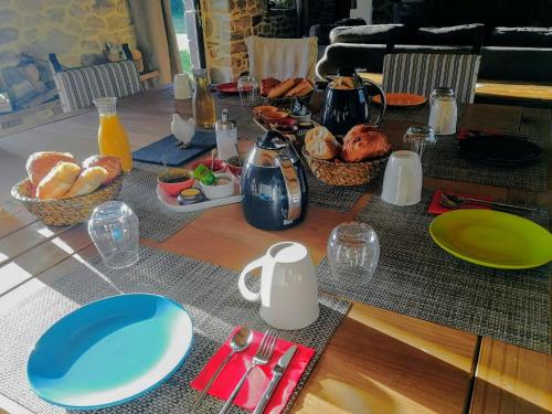 a table with plates and bowls of food on it at Les longères de keridy in Brech