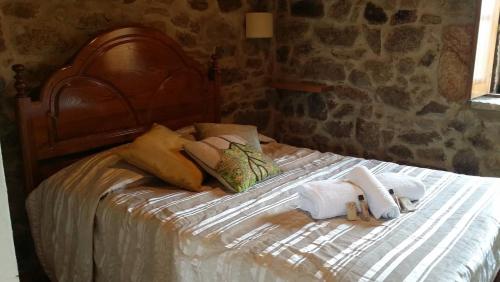 1 cama con 2 toallas y almohadas en Ares do Montemuro, en Campo Benfeito