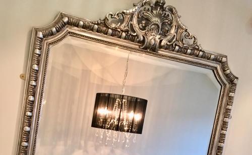 a mirror with a chandelier in a room at Hall Farm Hotel And Restaurant in Ashby cum Fenby