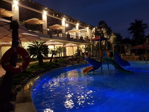 una piscina por la noche con un parque infantil en Sang Như Ngọc Resort en Chau Doc