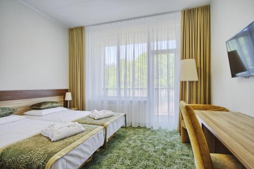 um quarto de hotel com duas camas e uma grande janela em Medical SPA "Eglės sanatorija" Standard Druskininkai em Druskininkai