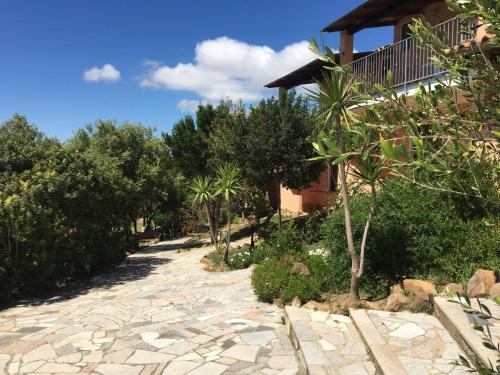 a path leading to a house with palm trees at Hotel Belvedere in Teulada