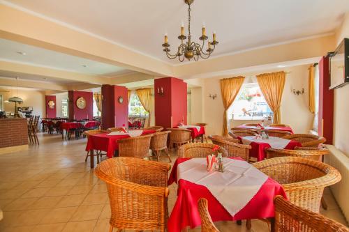 a restaurant with tables and chairs and a chandelier at Villa Antares I & II in Świnoujście