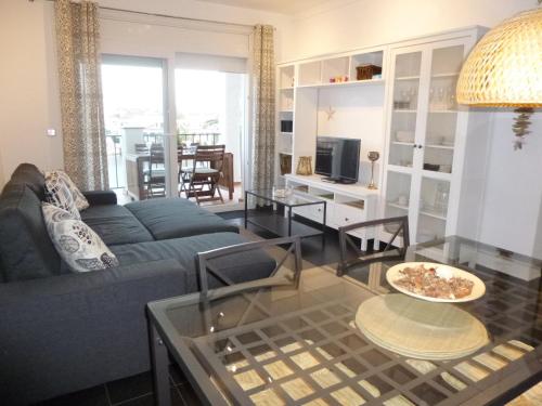 エンプリアブラバにあるApart-rent Apartment Sant Maurici 0137のリビングルーム(青いソファ、テーブル付)