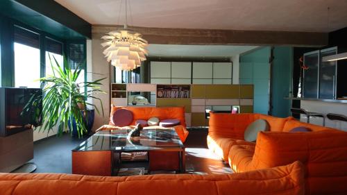 a living room with orange furniture and a chandelier at LOFT A RODA DE BERÀ in Roda de Bará