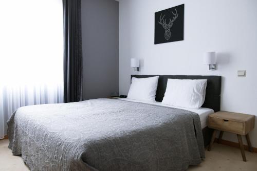 Schlafzimmer mit einem Bett mit weißer Bettwäsche und weißen Kissen in der Unterkunft Hotel De Fierlant in Brüssel