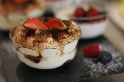 a cup of dessert with fruit on a table at S'O Smart B&B Tropea in Tropea