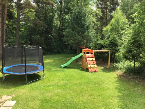 a yard with a playground with a slide and a play structure at Chata Dáša High Tatras in Mlynčeky