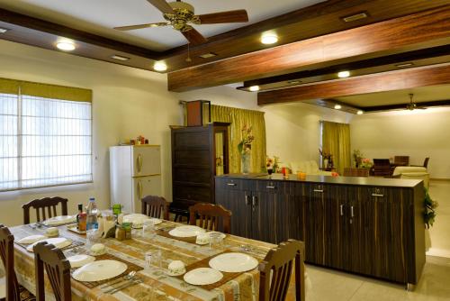 uma sala de jantar com uma mesa e uma cozinha em Pleasant Boulevard MG road em Bangalore