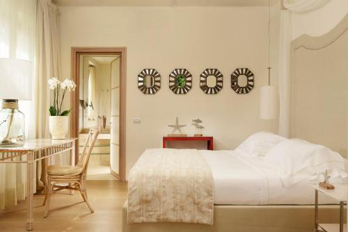 a bedroom with a bed and a desk and a chair at Villa Roma Imperiale in Forte dei Marmi