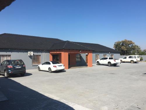 a parking lot with cars parked in front of a building at Vido Lodge and Conference Centre in Polokwane