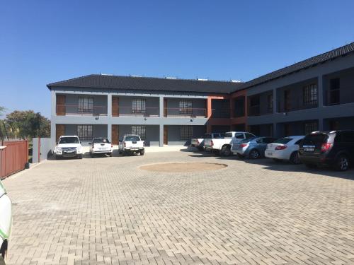 a parking lot with cars parked in front of a building at Vido Lodge and Conference Centre in Polokwane