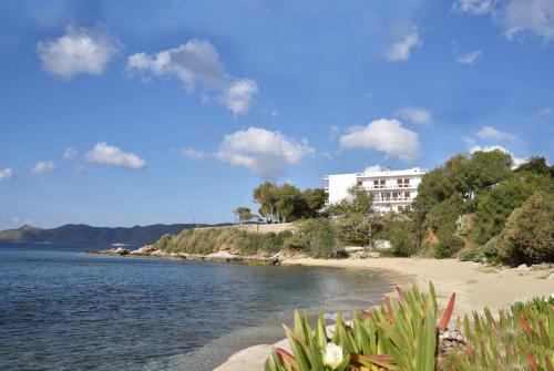 a building on a beach next to a body of water at Karystion Hotel in Karistos