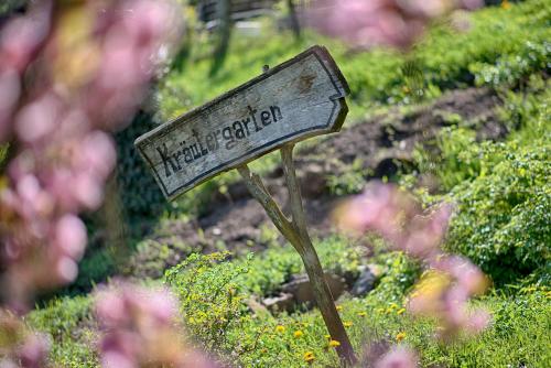a wooden sign in a field of flowers at Pension Christl in Caldaro