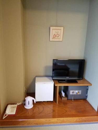 a room with a desk with a television and a computer at Hakuba Hotel Hana-no-Sato in Hakuba