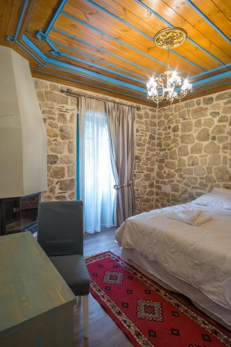 a bedroom with a bed and a stone wall at Hotel Arhontiko Vourloka in Pramanta