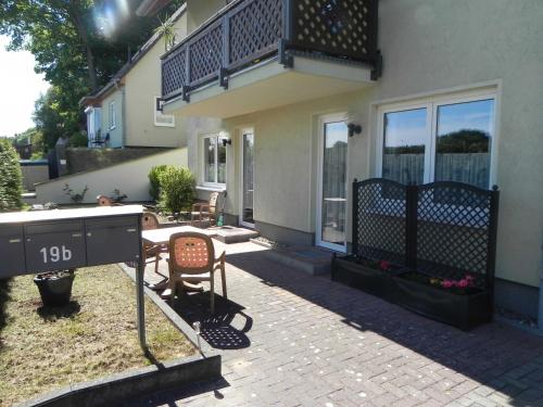 a house with a patio with a table and a balcony at Brandt Ferienwohnungen Jägersberg in Ahlbeck