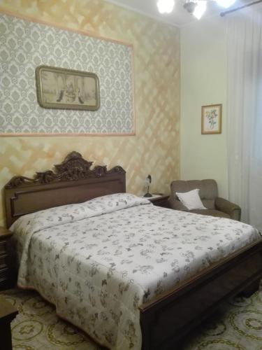 a bedroom with a large bed and a chair at Casa Panoramica Vintage in Tramonti