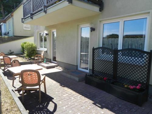 een patio met stoelen en een tafel voor een huis bij Brandt Ferienwohnungen Jägersberg in Ahlbeck