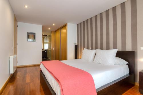 a bedroom with a large white bed with a red blanket at Pretty Porto Apartment by SOULSHARING.PORTO in Porto