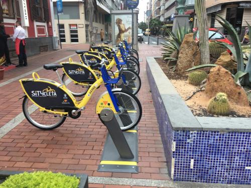 a row of bikes parked in a row on a sidewalk at Numancia 1 - 4A in Las Palmas de Gran Canaria